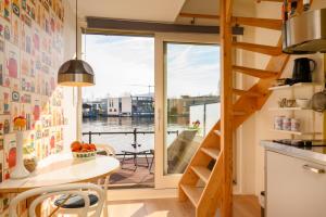 阿姆斯特丹Houseboat studio with canalview and free bikes的厨房配有桌子和大窗户