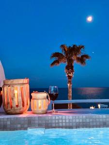 卡马利马克里斯海滩公寓式酒店的一杯葡萄酒和一棵棕榈树,旁边是游泳池