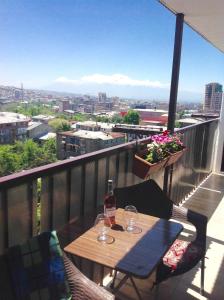 埃里温Lily`s Loft的阳台上的桌子和两杯酒杯