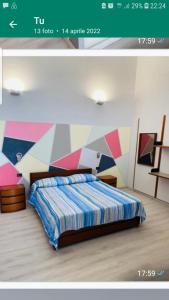 BoissanoGemy的一间卧室配有一张带彩色墙壁的床