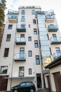 布拉格Designed apartment next to Vaclav square with terrace and private garage的前面有停车位的建筑