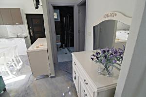 斯卡拉卡里拉奇斯Olga's Suite Al Mar的浴室的柜台上装有紫色花瓶