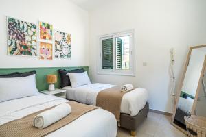 拉纳卡Spacious 3-Bedroom House in Larnaca的客房设有两张床和窗户。