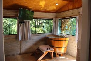 圣安东尼奥-杜皮尼亚尔Jardim Suspenso da Babilônia的带窗户的客房内设有带木制浴缸的木制浴室