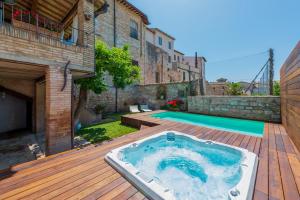 斯佩洛Villa Elisa的游泳池旁甲板上的热水浴池