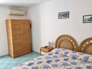 蓬扎Vento di Terra Ponza的一间卧室配有一张床和一个木制橱柜