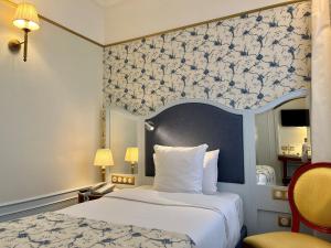 巴黎巴黎梅费尔酒店的一间卧室配有一张带蓝白色图案墙壁的床
