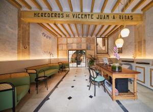 马略卡岛帕尔马Fil Suites的一间设有绿椅和桌子的餐厅