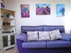 伊斯兰蒂拉Magnífico adosado de esquina con vistas al golf playas Islantilla的客厅里一张紫色的沙发,墙上挂着绘画作品