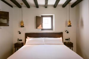 伊维萨镇玛卡酒店的卧室配有一张大白色床和窗户