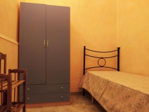 托雷拉皮罗Casa Vacanze da Antonio的一间卧室配有一张床和一个梳妆台,旁边是一个橱柜