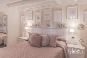莫诺波利Masseria Fabula Bistrot & Maison的白色卧室配有带粉红色枕头的床