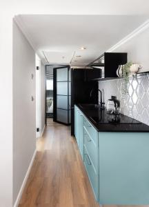 荷兹利亚Seaview Stylish Apartment with Balcony的厨房配有蓝色橱柜和黑色台面