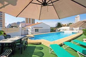 卡尔佩Villa Calalga - PlusHolidays的一座带桌子和遮阳伞的建筑屋顶游泳池