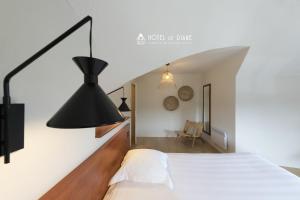 萨布勒多尔莱潘黛安酒店的卧室配有白色的床和黑灯