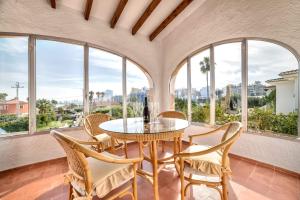 卡尔佩Villa Benicolada - PlusHolidays的一间带桌椅和窗户的用餐室