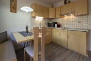 修希Apartments Woerndle的厨房配有木制橱柜和木桌。