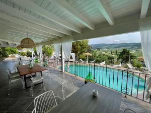 佩斯基奇Borgo del Nespolo的一个带桌椅的庭院和一个游泳池