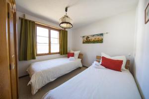 阿尔瓦努Ferienhaus Alvaneu für Familien的一间卧室设有两张床和窗户。