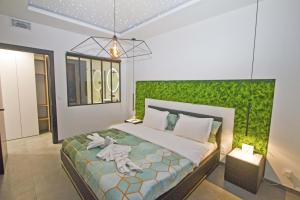 尼斯Luxury Garden Jacuzzi Promenade的一间卧室配有一张带绿色墙壁的床