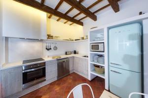 休达德亚SANT ISIDRE 50的一间大厨房,配有白色的橱柜和一台冰箱