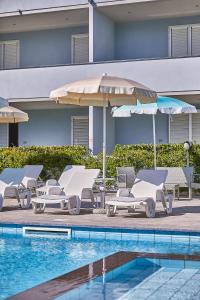切齐纳码头Golden Hotel的一组躺椅和遮阳伞,位于游泳池旁