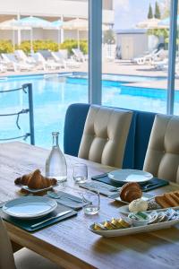切齐纳码头Golden Hotel的餐桌,餐盘和游泳池