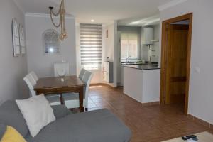 诺沃桑克蒂佩特里Apartamento Jardin del Golf的客厅以及带沙发和桌子的厨房。
