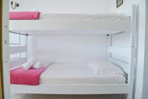 EmpouriosXALAKAS SUMMER HOUSE的一间卧室配有两张双层床和粉红色床单