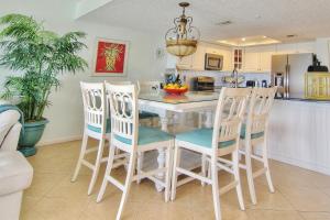 圣徒皮特海滩Ram Sea I 206的厨房配有桌子和四把椅子
