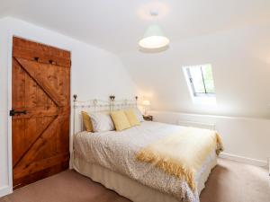 欧克汉普敦Nuthatch Cottage的一间卧室配有一张带木门的床