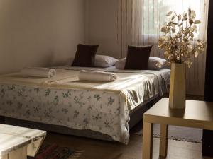 RavnoApartment Village house的一间带两张床的卧室和鲜花花瓶