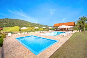 塞拉内格拉Filimahalo Hotel的度假村内带椅子和遮阳伞的游泳池