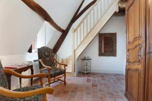 博讷美资艾尔修道院酒店的走廊上设有椅子、桌子和楼梯