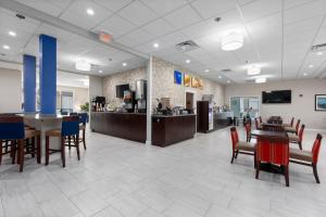 黑泽尔伍德Comfort Inn & Suites St Louis-Hazelwood的一个带桌椅的大堂和一间自助餐厅