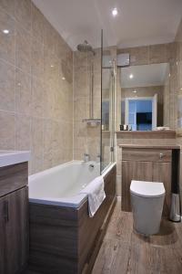蒂恩格托拉瓦格别墅酒店的带浴缸和卫生间的浴室。