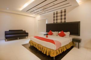 AmeerpetOYO Hotel Palak Residency Near Erragadda Metro Station的一间卧室配有一张大床和一把椅子