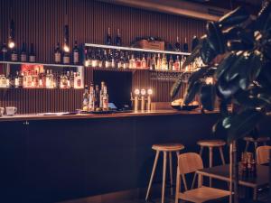 哥德堡弗洛拉酒店的酒吧设有凳子和酒瓶
