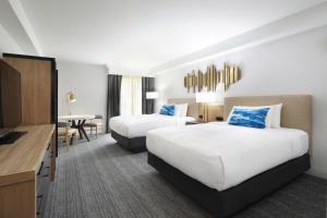 米尔皮塔斯Sonesta Silicon Valley的酒店客房配有两张床和一张书桌