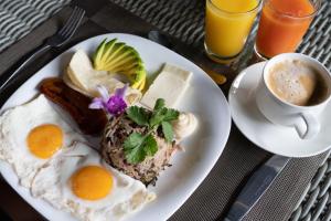 福尔图纳Tifakara Boutique Hotel & Birding Oasis的包括鸡蛋和咖啡的早餐盘