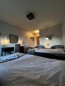 斯特伦松德诺第卡斯托姆桑德酒店的客房设有两张床、一张桌子和一台电视。
