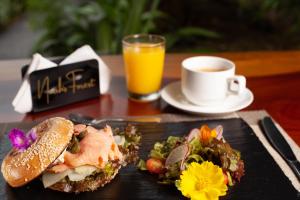 福尔图纳Tifakara Boutique Hotel & Birding Oasis的一块带三明治和橙汁的食物