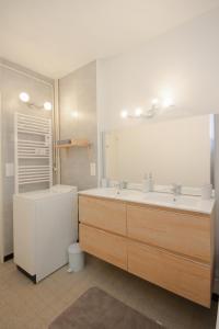 布里昂松Coquet appartement Type 2 de 56 m² en centre ville的浴室设有2个水槽、浴缸和镜子