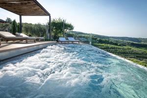 Mezzane di Sotto塔玛索蒂雷莱斯迪坎帕格纳1号酒店的游泳池设有2个长凳,水面充盈