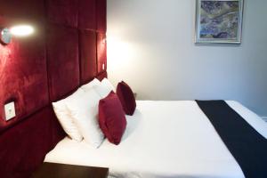 布莱克浦The Bromley的一间卧室配有红色和白色枕头的床