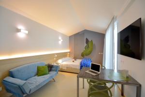 里乔内Prime Blue Suite - Appartamenti con jacuzzi privata的客厅配有沙发和带笔记本电脑的桌子