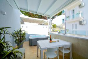 里乔内Prime Blue Suite - Appartamenti con jacuzzi privata的阳台配有白色桌椅和浴缸。