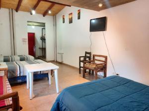 普尔马马尔卡La Posada de la Calandria的卧室配有一张床,墙上配有电视。