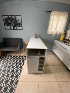 楚伊Apartamento el uno的小厨房配有白色的柜台和桌子