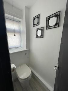 新罗姆尼Romney Sands Holiday Apartment的浴室设有卫生间,墙上有三面镜子。